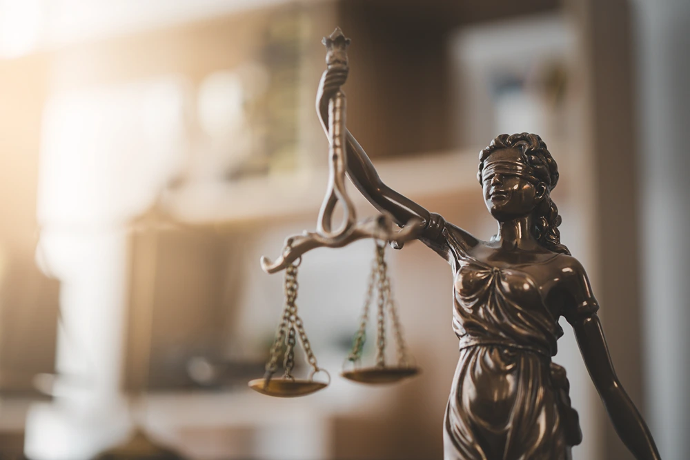 bronze statue of lady justice in a sunlit office
