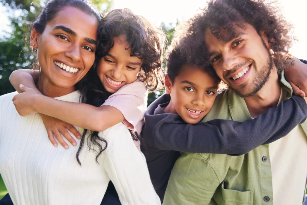 happy family hugging outside in the sunlight