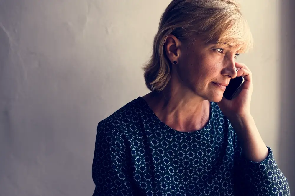 woman talking on phone near the window
